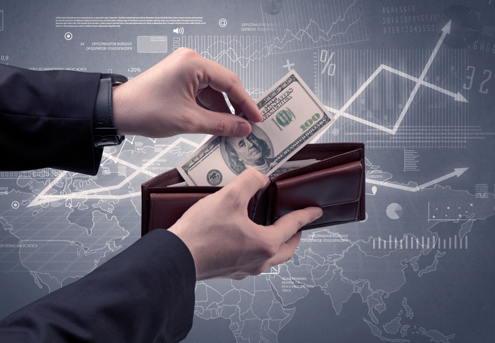 Businessmans hand takes out dollar from wallet with finance graphic on the background